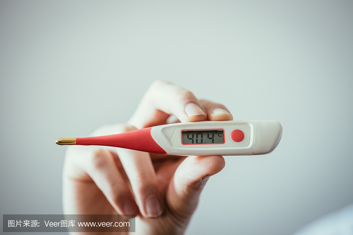 一個人手里拿著一個發(fā)熱溫度計